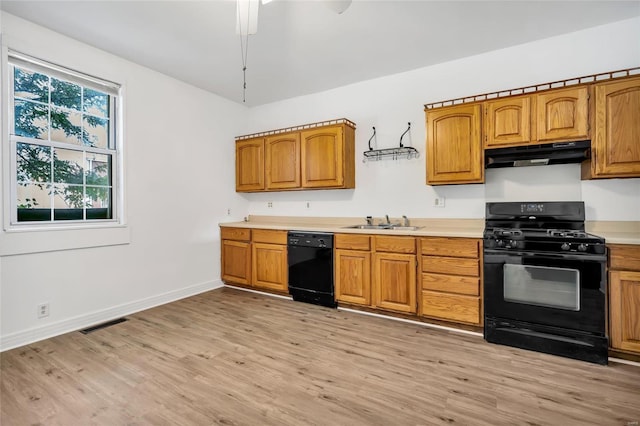 kitchen featuring black appliances, sink, and light hardwood / wood-style flooring