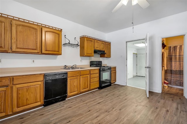 kitchen with ceiling fan, sink, black appliances, and light hardwood / wood-style floors