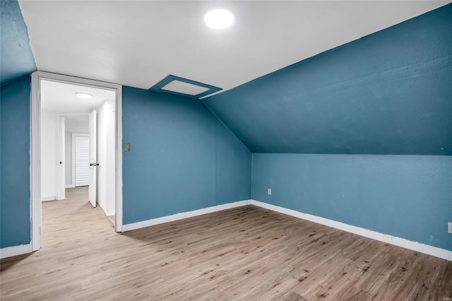 bonus room with vaulted ceiling and light hardwood / wood-style flooring