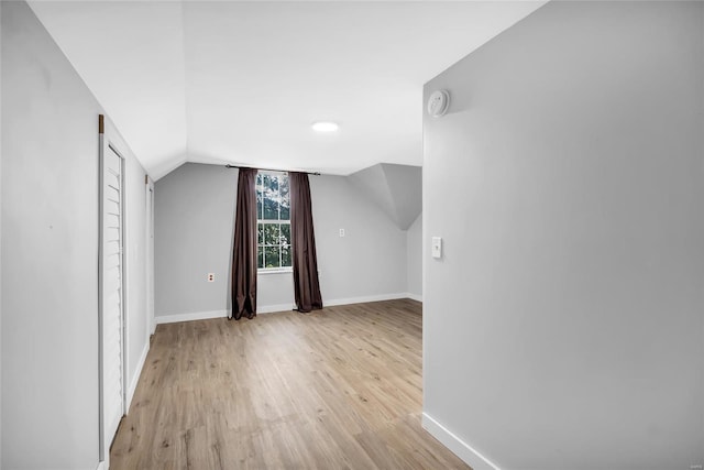 bonus room featuring light wood-type flooring and vaulted ceiling