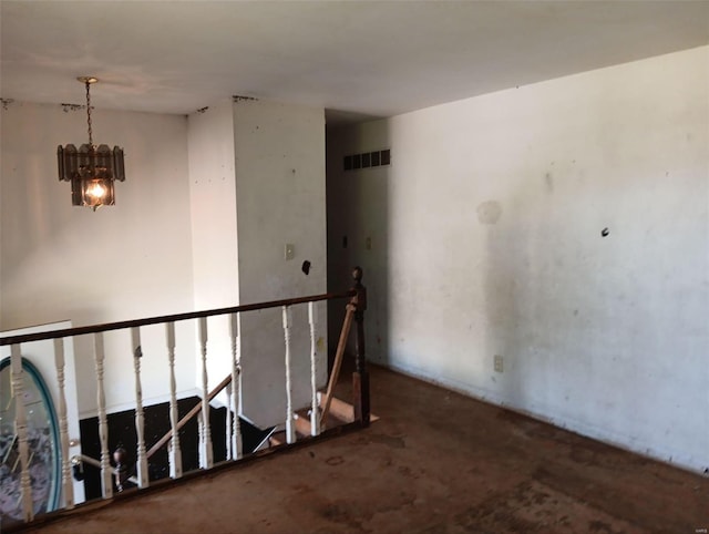 unfurnished room featuring an inviting chandelier