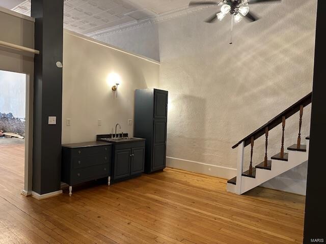 foyer with light wood-type flooring, ceiling fan, crown molding, and sink