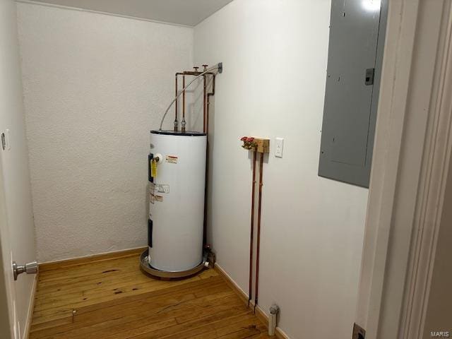 utility room featuring electric panel and water heater