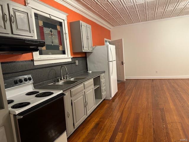 kitchen featuring dark hardwood / wood-style flooring, tasteful backsplash, white appliances, crown molding, and range hood