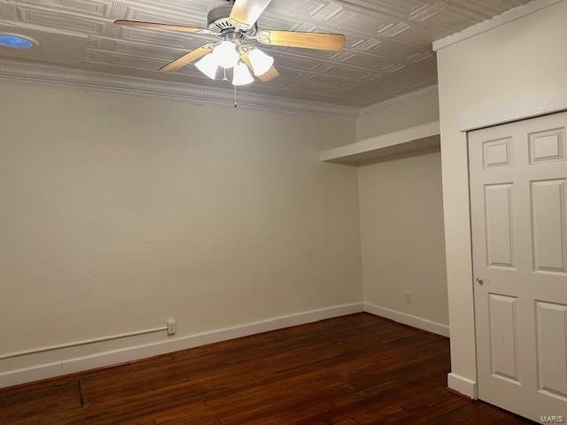 empty room with dark hardwood / wood-style floors, ceiling fan, and crown molding