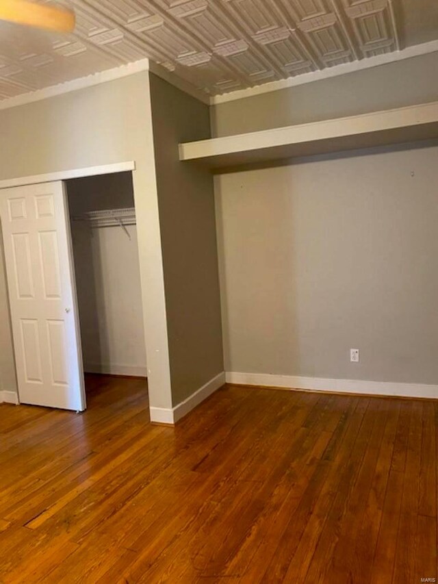 unfurnished bedroom with wood-type flooring and a closet