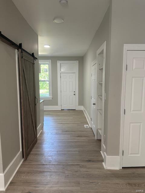 hall featuring a barn door and light wood-type flooring