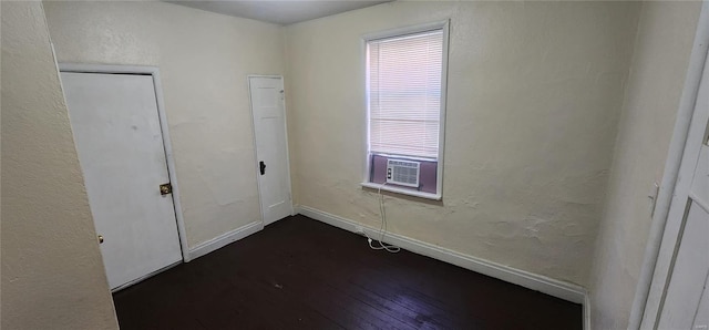 unfurnished bedroom with cooling unit and dark hardwood / wood-style flooring