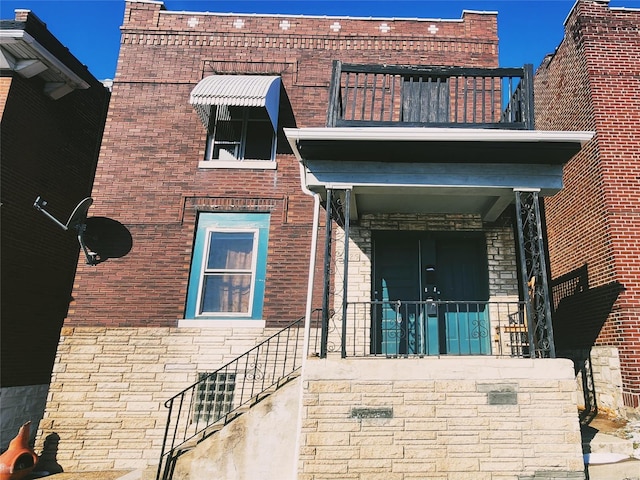 view of exterior entry featuring a balcony