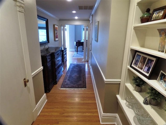 hallway featuring wood-type flooring and ornamental molding