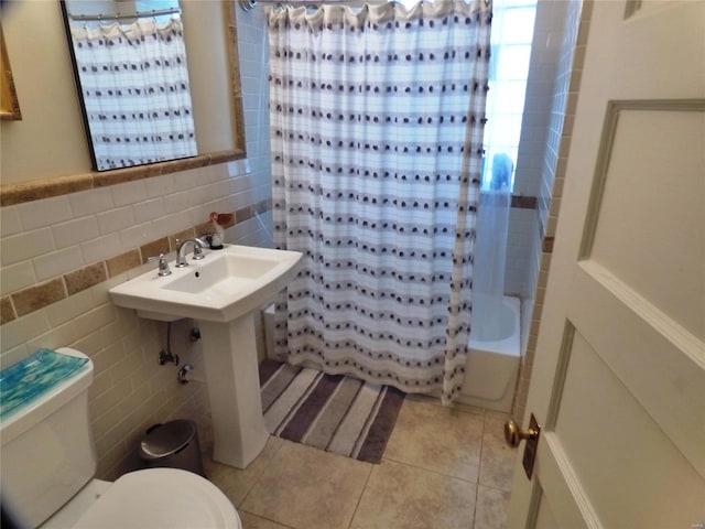 bathroom featuring tile patterned flooring, toilet, tile walls, and shower / tub combo