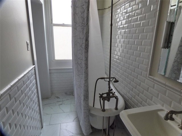 bathroom featuring sink and tile walls