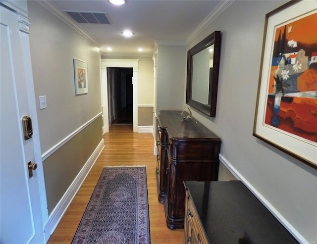 corridor featuring light wood-type flooring and ornamental molding