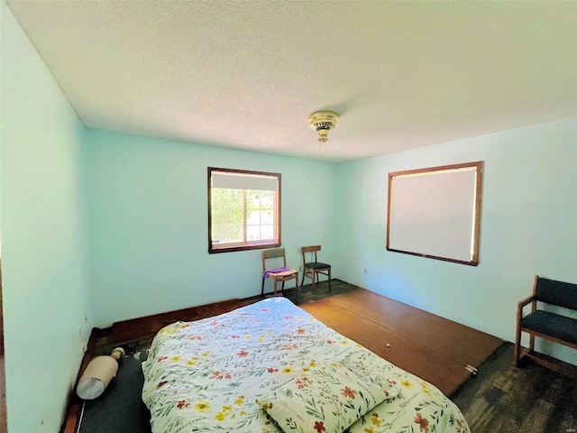 bedroom featuring a textured ceiling and dark wood-type flooring