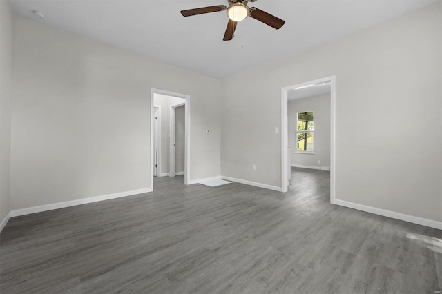 empty room with ceiling fan and dark wood-type flooring