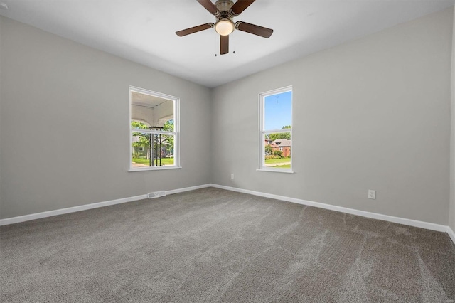 empty room with carpet flooring, a wealth of natural light, and ceiling fan