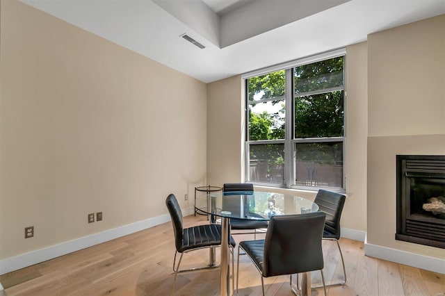 dining room with a wall of windows and light wood-type flooring