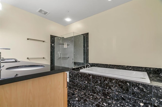 bathroom featuring shower with separate bathtub and vanity