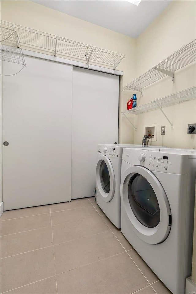 laundry area featuring independent washer and dryer and light tile patterned flooring