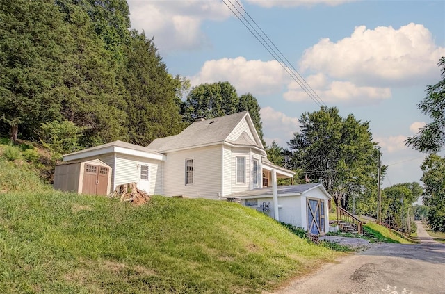 view of side of home featuring a lawn, an outdoor structure, and a garage