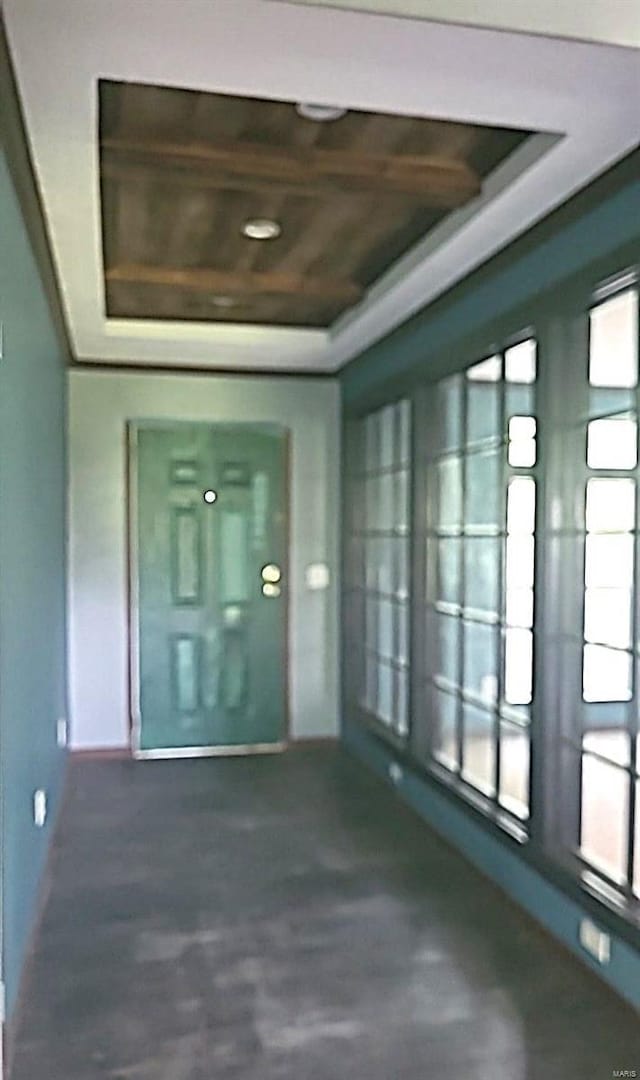 interior space featuring wooden ceiling and a tray ceiling