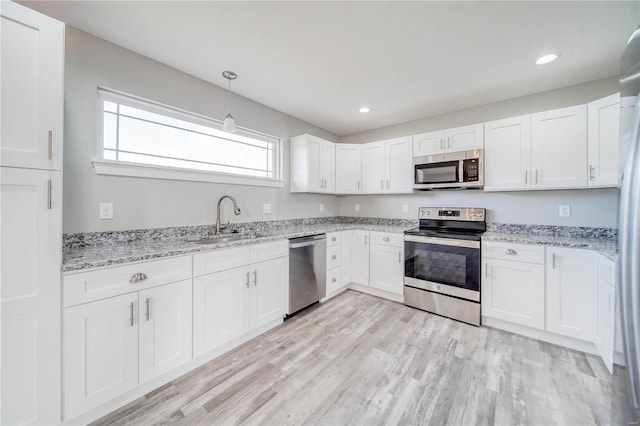 kitchen with sink, light hardwood / wood-style flooring, stainless steel appliances, and white cabinets