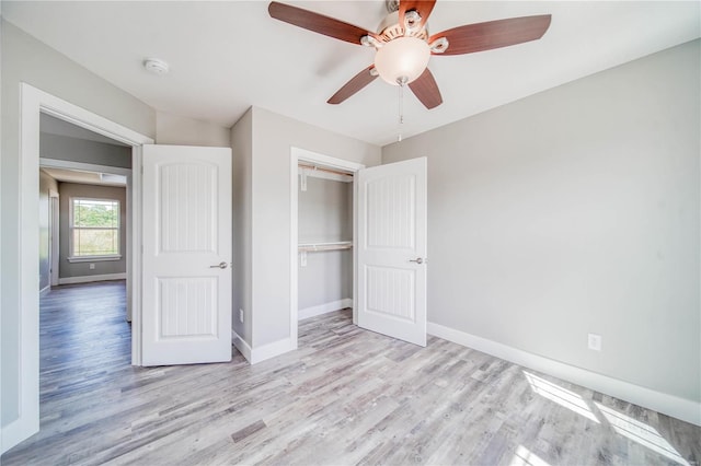 unfurnished bedroom with ceiling fan, a closet, and wood-type flooring