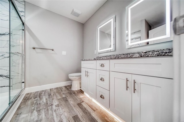 bathroom featuring vanity, walk in shower, wood-type flooring, and toilet