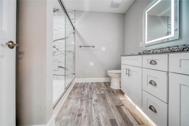 bathroom with vanity, toilet, a shower with door, and hardwood / wood-style floors