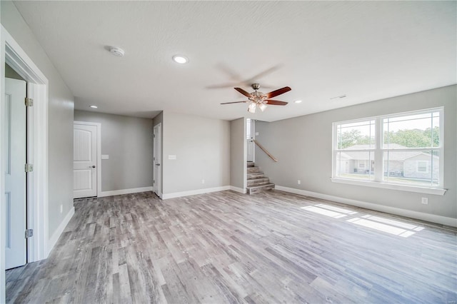 unfurnished living room featuring light hardwood / wood-style flooring and ceiling fan