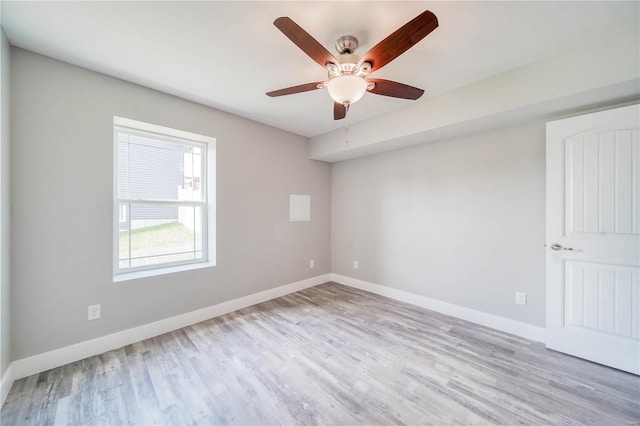 empty room with ceiling fan and light hardwood / wood-style flooring