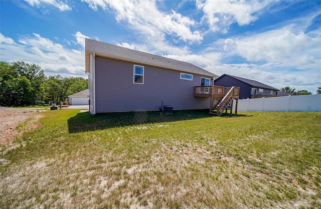 back of house featuring central air condition unit, a deck, and a yard