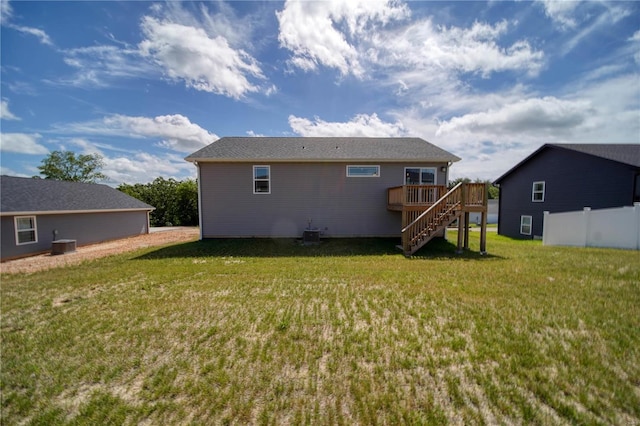 back of house featuring a deck and a lawn