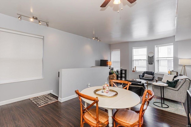 dining room featuring ceiling fan, dark hardwood / wood-style flooring, and track lighting