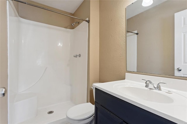 bathroom featuring vanity, toilet, and walk in shower