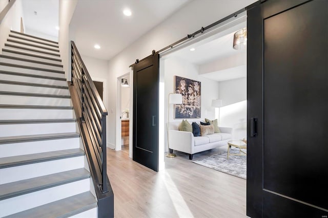 stairs with hardwood / wood-style floors and a barn door