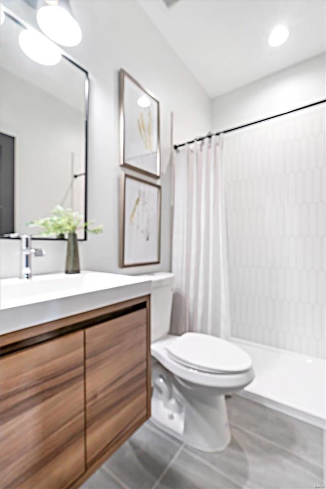 bathroom with tile patterned flooring, vanity, toilet, and curtained shower