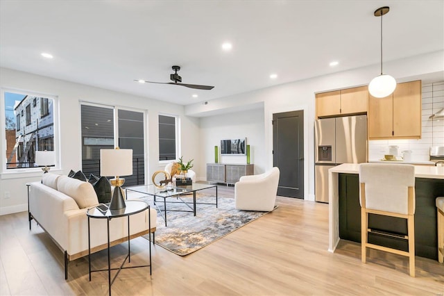 living room featuring ceiling fan and light wood-type flooring