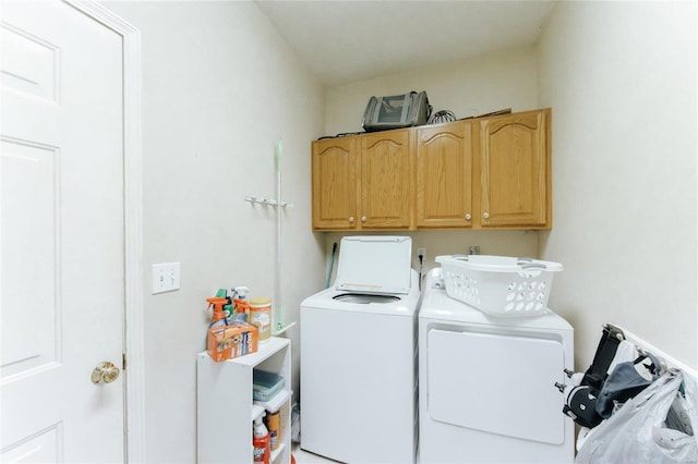 laundry area with washer and clothes dryer and cabinets