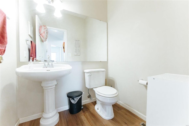 bathroom featuring hardwood / wood-style floors and toilet