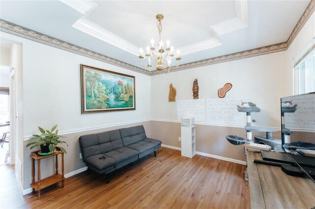 sitting room with a notable chandelier, hardwood / wood-style floors, and a tray ceiling