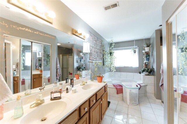 bathroom with tile flooring, dual vanity, and a bath