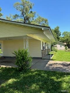 view of home's exterior featuring a carport and a lawn