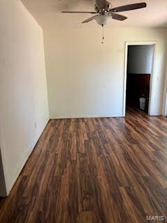 unfurnished room featuring dark wood-type flooring and ceiling fan