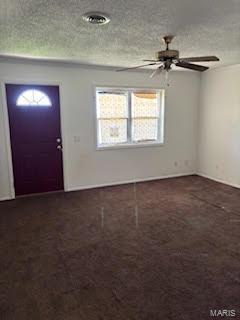 foyer with ceiling fan and a textured ceiling