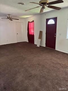 carpeted entrance foyer with a textured ceiling and ceiling fan