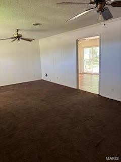 carpeted spare room featuring a textured ceiling and ceiling fan