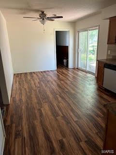 unfurnished living room featuring ceiling fan and dark hardwood / wood-style floors