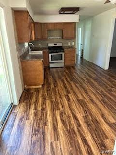 kitchen featuring dark wood-type flooring, sink, and stainless steel range with electric cooktop