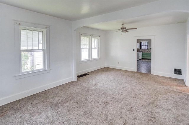 spare room with carpet floors, ceiling fan, and a healthy amount of sunlight